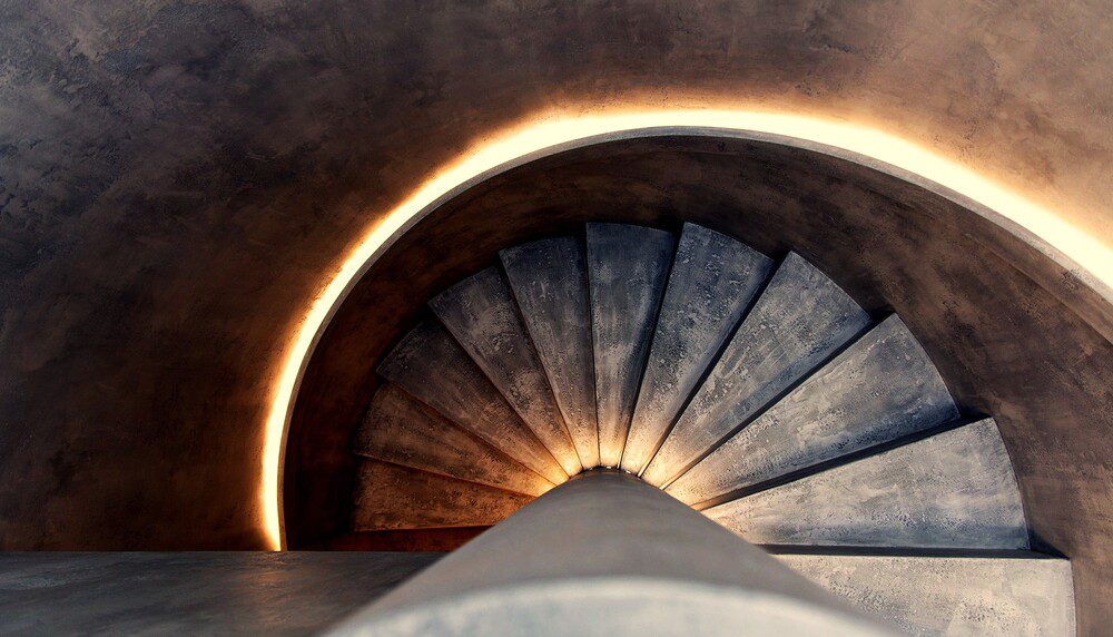 Spiral staircase glowing with light from behind, representing attunement and crossing the threshold to higher perception